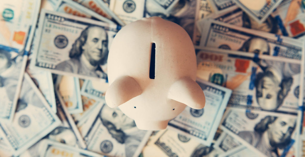 above view of piggie bank standing on one hundred dollar bills what is an annuity chicago il