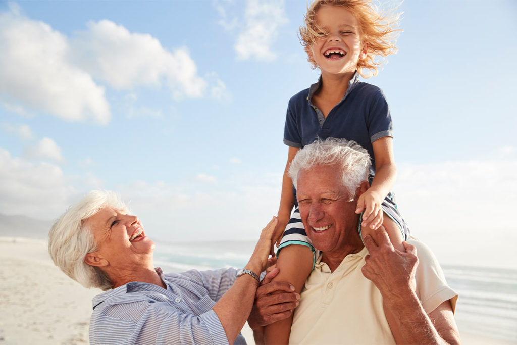 smiling grandparents on the beach grandson on grandpas shoulders fixed index annuity chicago il